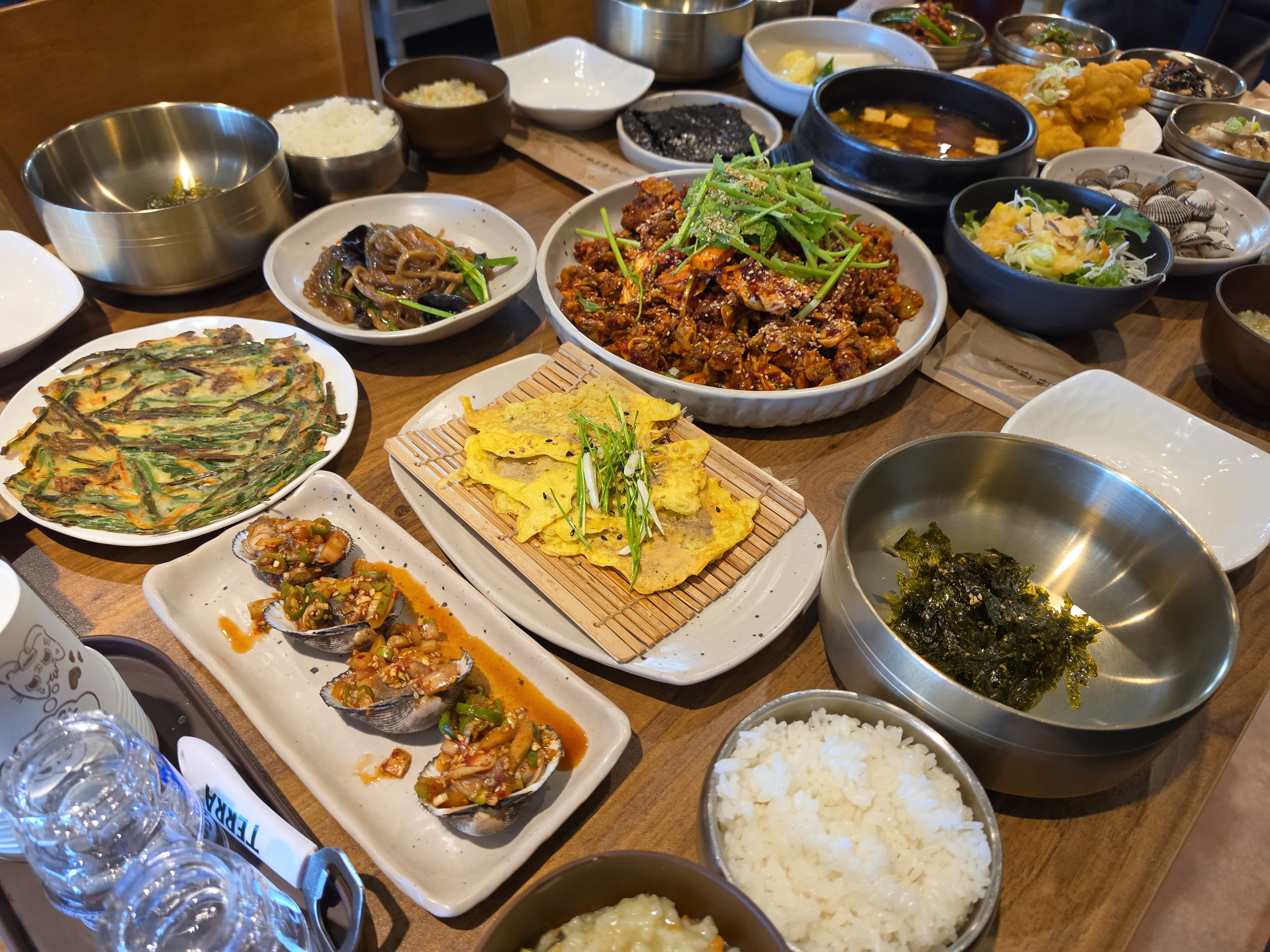 꼬막과 다양한 음식이 함께 보이는 식탁